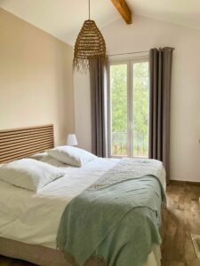 Séjour spacieux avec plafond cathédrale, poutres apparentes et cuisine ouverte entièrement équipée.