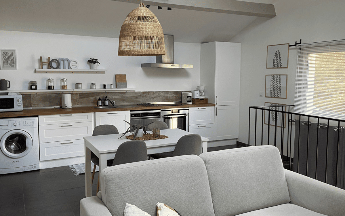 Vue d'ensemble du séjour lumineux avec canapé confortable et table à manger.