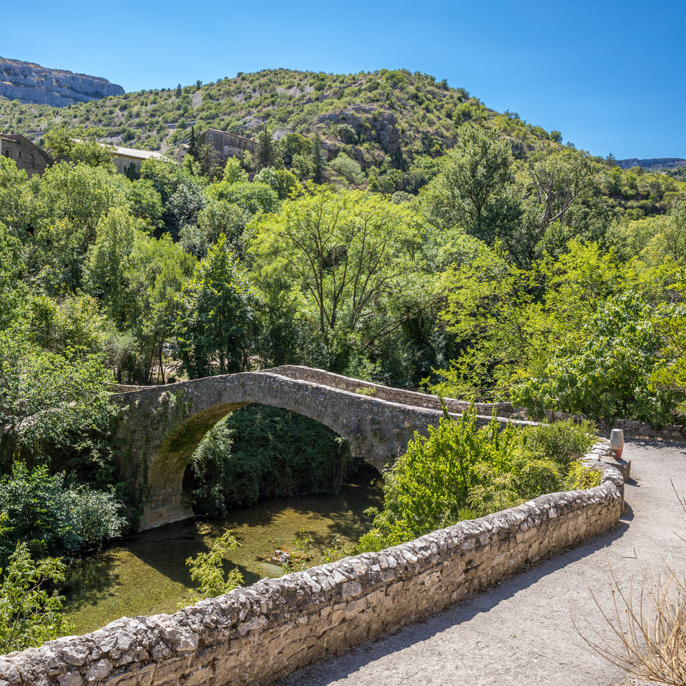 Vieux pont en pierre pittoresque au-dessus de la rivière, site touristique incontournable près du Pic Saint-Loup.